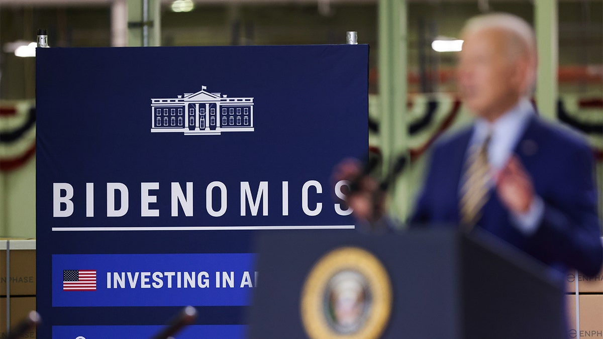 President Joe Biden blurred with Bidenomics sign in focus