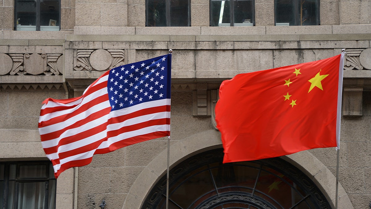 The national flags of the United States and China flutter at the Fairmont Peace Hotel on April 25, 2024 in Shanghai.