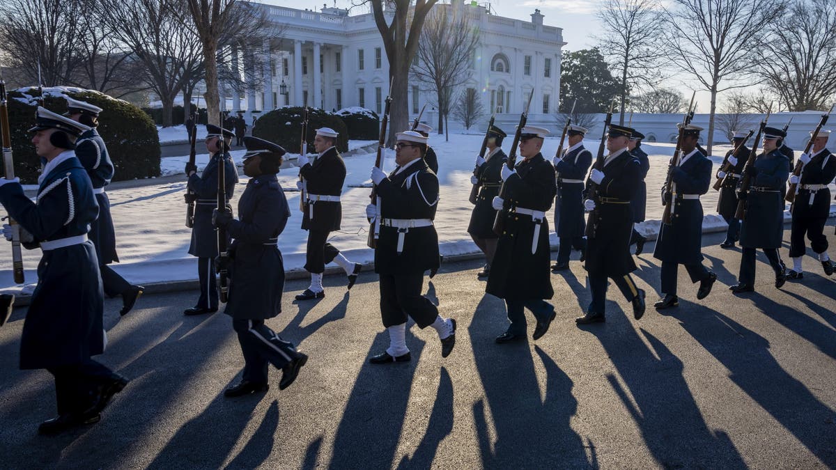 The U.S. military Joint Honor Guard is pictured rehearsing outside the White House, which is blanketed in snow 