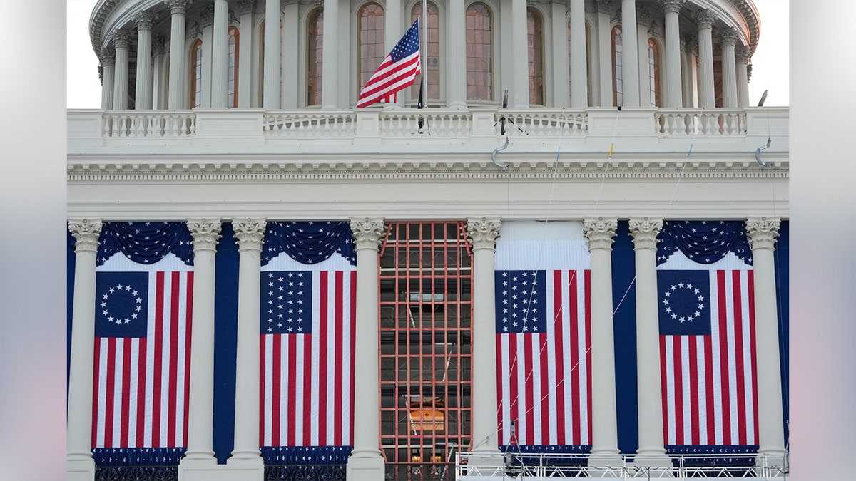 A view of the White House with American flags draped between columns.