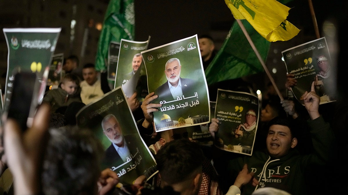 Palestinians hold posters of Ismail Haniyeh