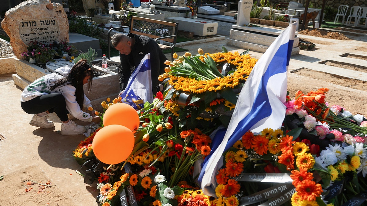 Flowers on the graves of Shiri, Ariel and Kfir Bibas