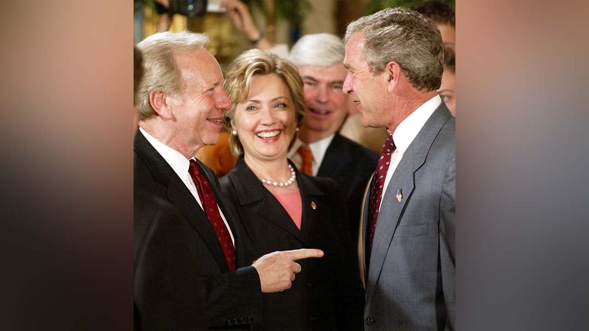 President George W. Bush speaks with Sens. Joe Lieberman and Hillary Clinton after an event in the East Room of the White House, June 17, 2003.