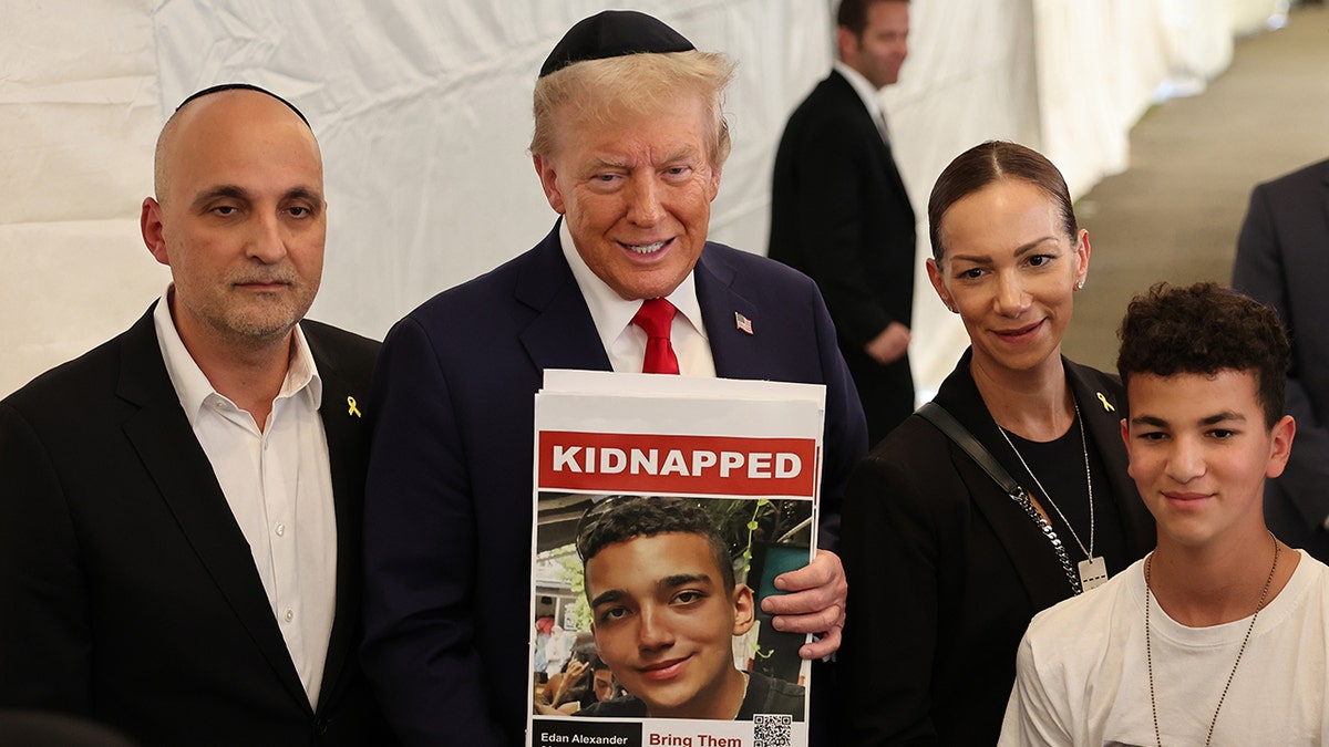 Donald Trump holding photo of Edan Alexander